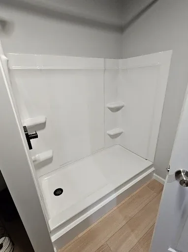 Spotlessly clean white walk-in shower after deep cleaning