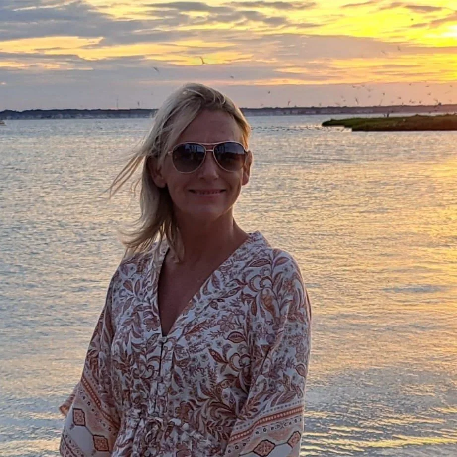 Nina, owner of Nina's Cleaning Service, smiling at sunset